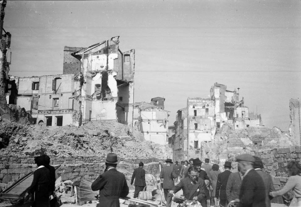 Italy_people_moving_through_rubble_of_bombed_buildings_in_Florence